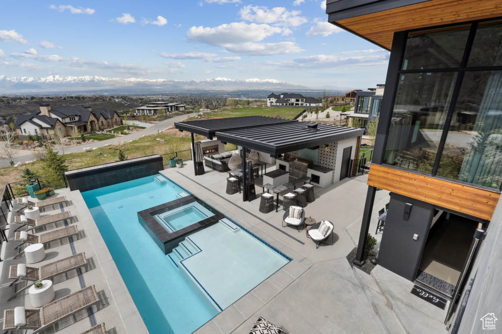 View of swimming pool with a patio and an in ground hot tub