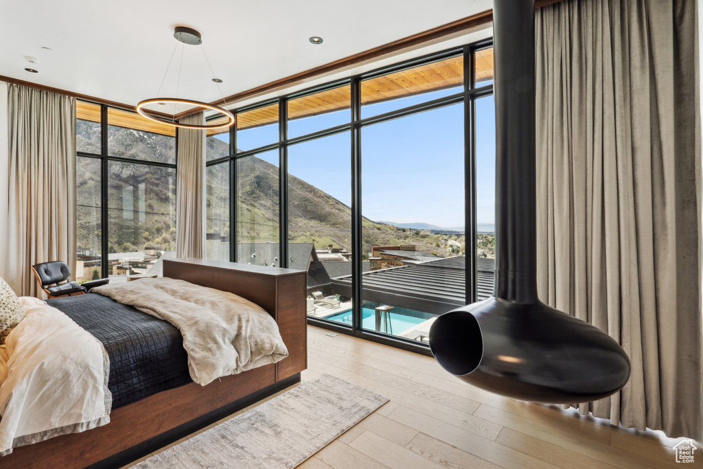 Bedroom with a mountain view, light hardwood / wood-style floors, and expansive windows