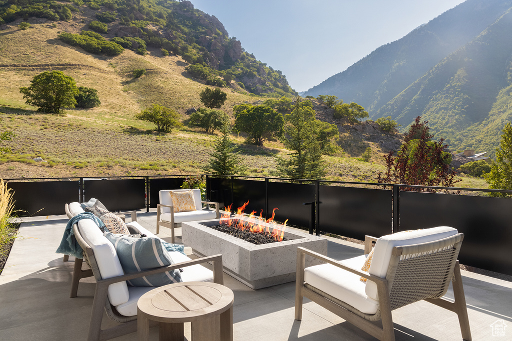 View of patio with a mountain view and an outdoor living space with a fire pit
