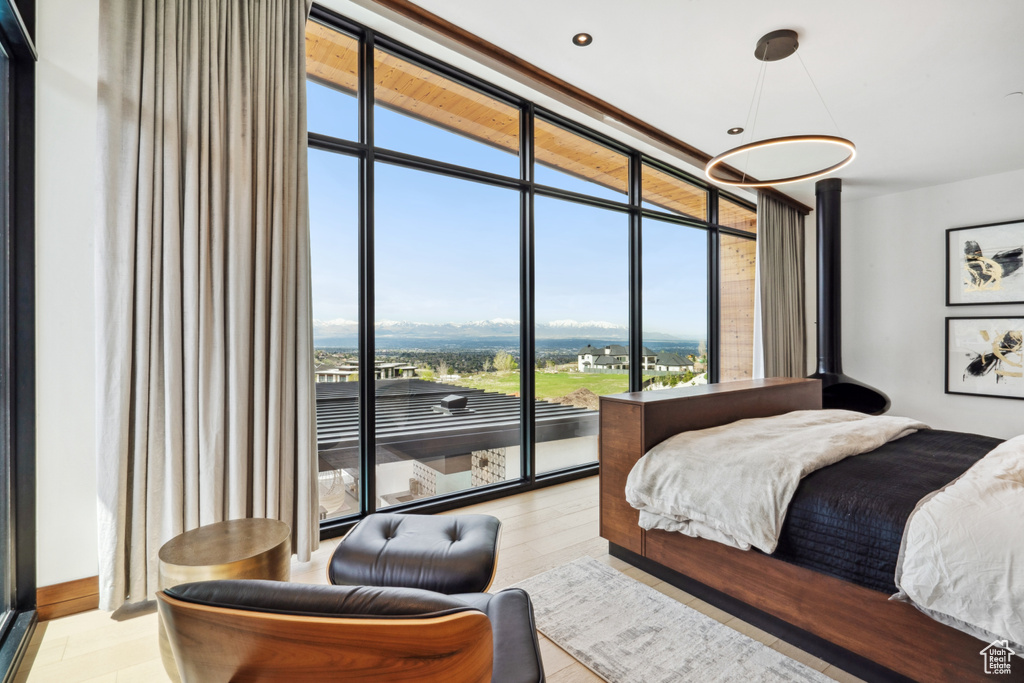 Bedroom with floor to ceiling windows and light hardwood / wood-style flooring