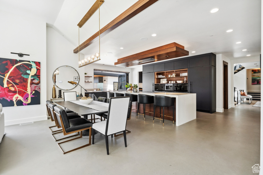 Dining space featuring concrete flooring and beamed ceiling