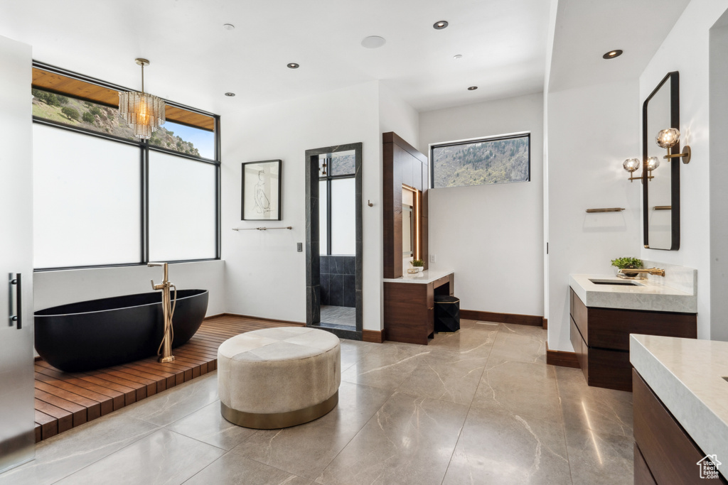 Bathroom with tile floors, a bathtub, and double sink vanity