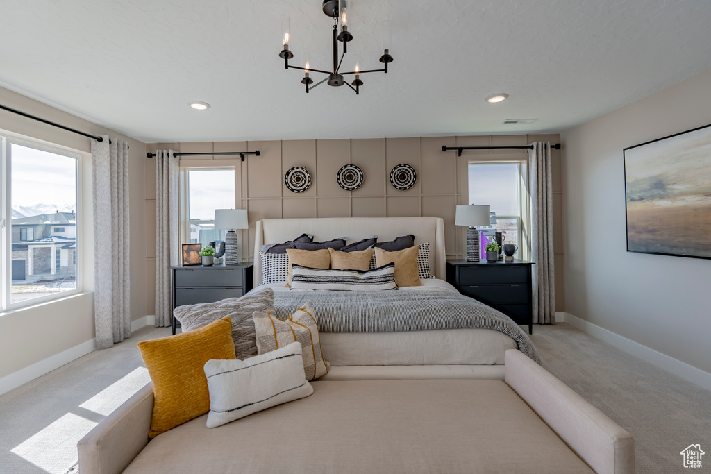 Carpeted bedroom featuring an inviting chandelier