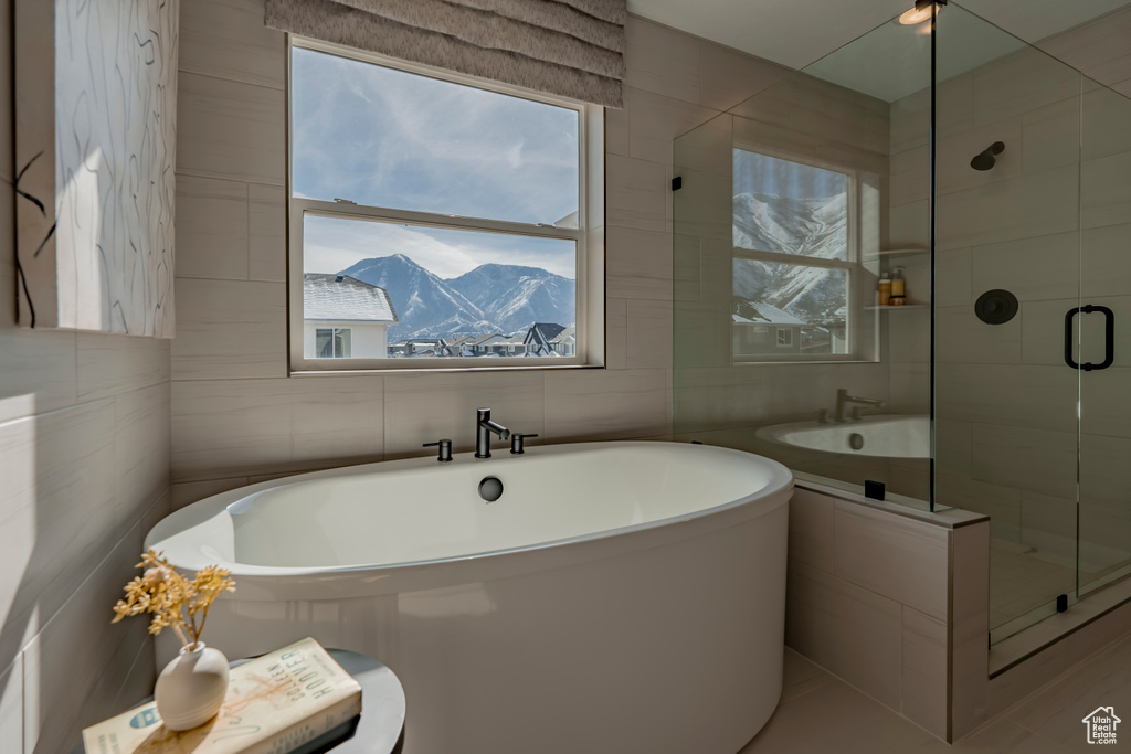 Bathroom with a wealth of natural light, a mountain view, and tile walls