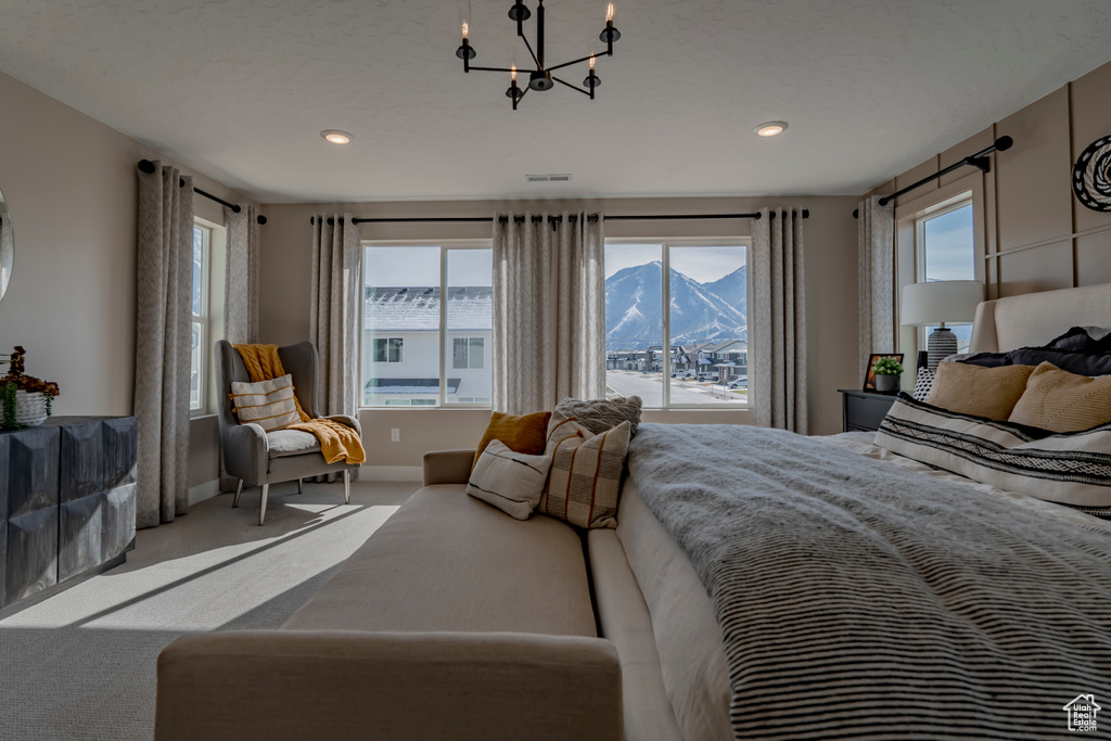 Bedroom featuring carpet floors, a mountain view, and a chandelier