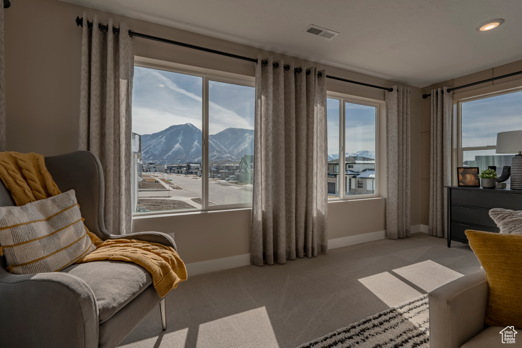Living area with a mountain view and carpet