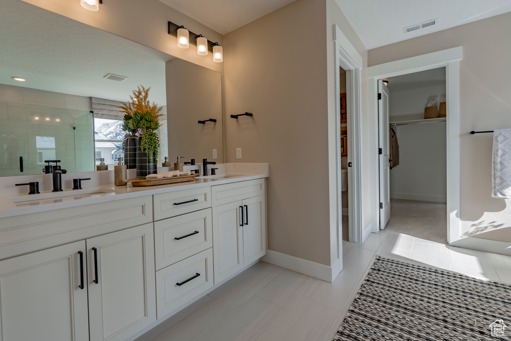 Bathroom with tile flooring, dual sinks, and oversized vanity