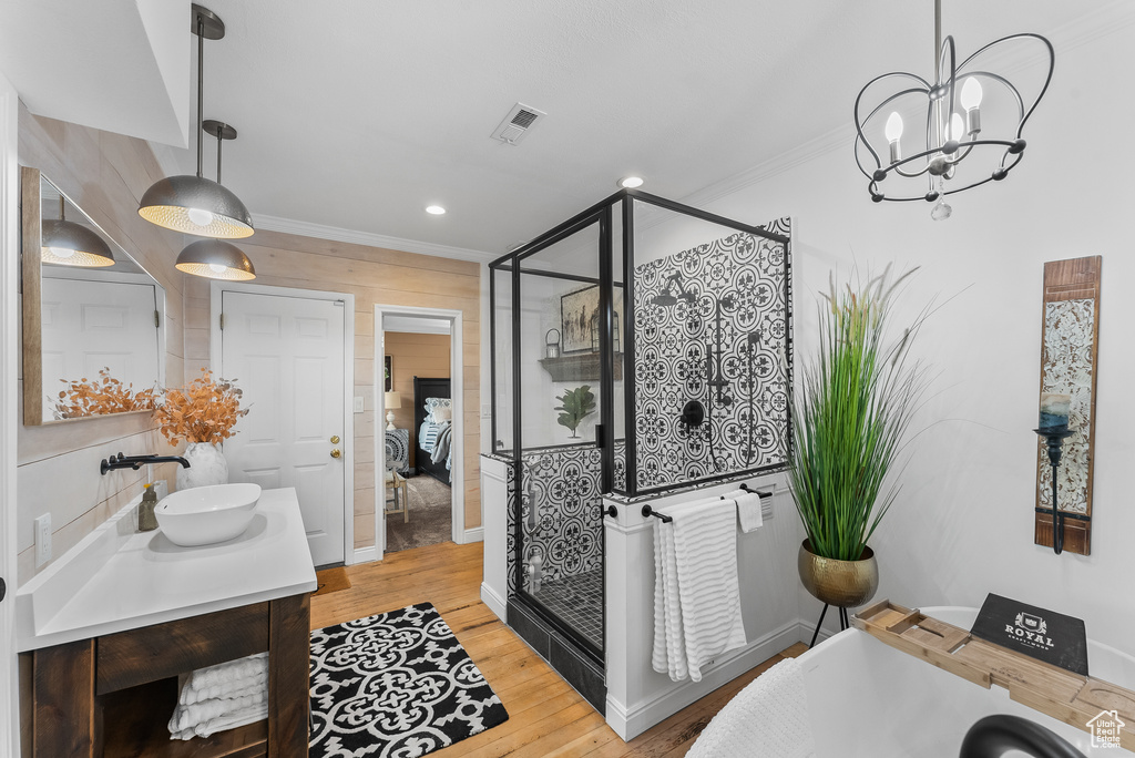 Bathroom featuring hardwood / wood-style floors, crown molding, an enclosed shower, and large vanity