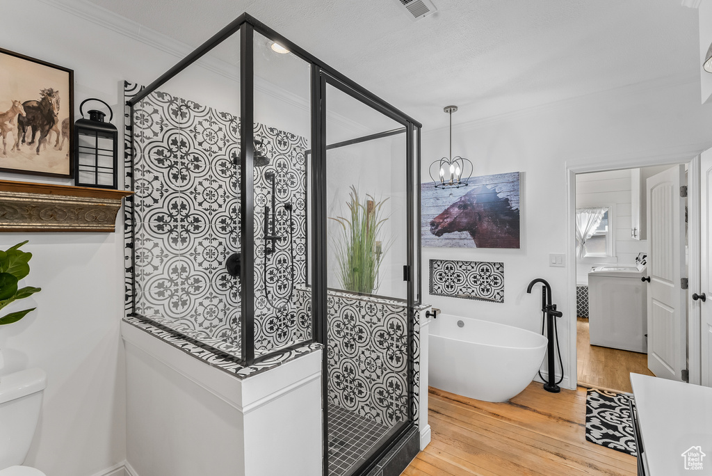 Bathroom with plus walk in shower, hardwood / wood-style floors, toilet, and ornamental molding