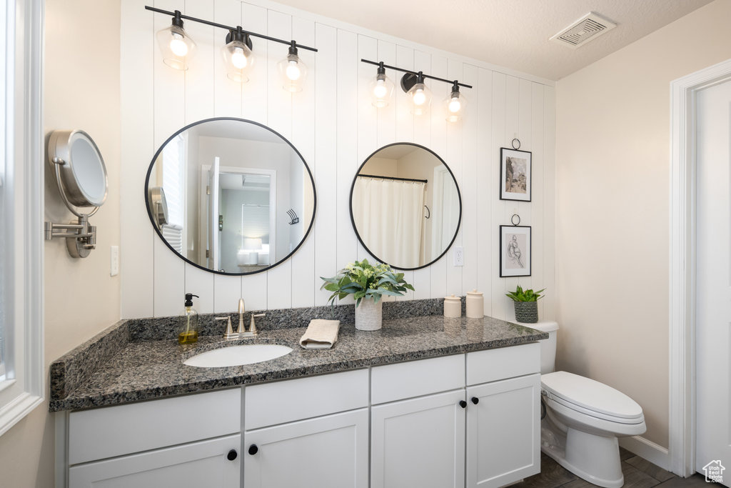 Bathroom featuring tile floors, vanity, toilet, and a textured ceiling