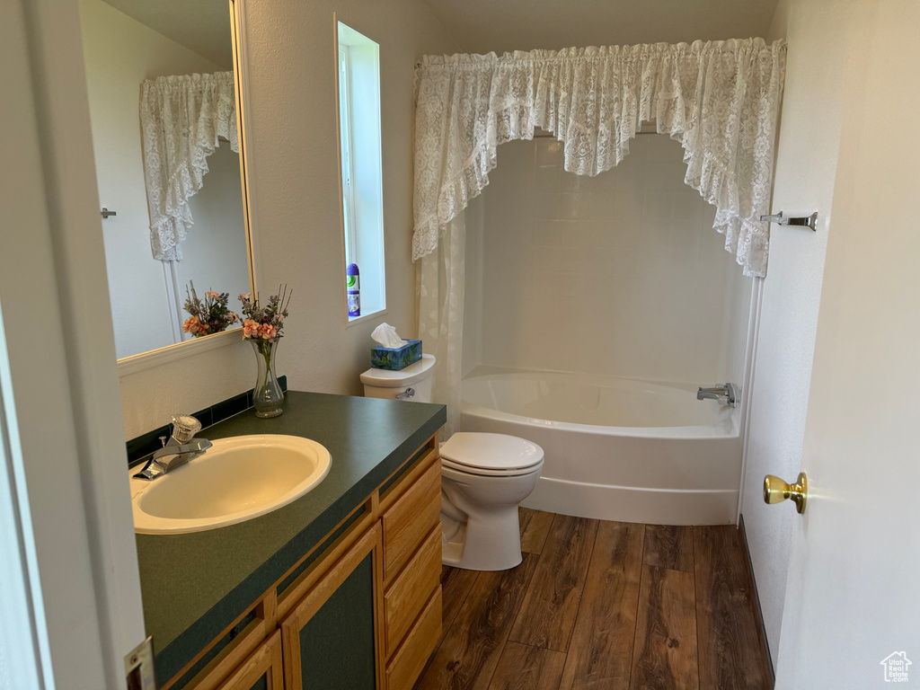 Bathroom featuring toilet, oversized vanity, and hardwood / wood-style floors