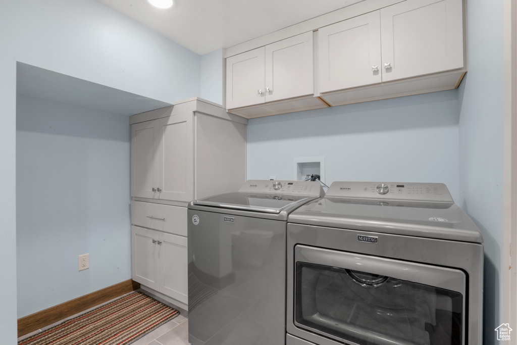 Laundry area with tile flooring, independent washer and dryer, cabinets, and hookup for a washing machine
