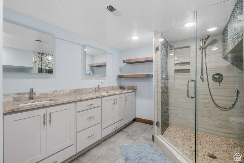 Bathroom featuring walk in shower, dual bowl vanity, and tile floors
