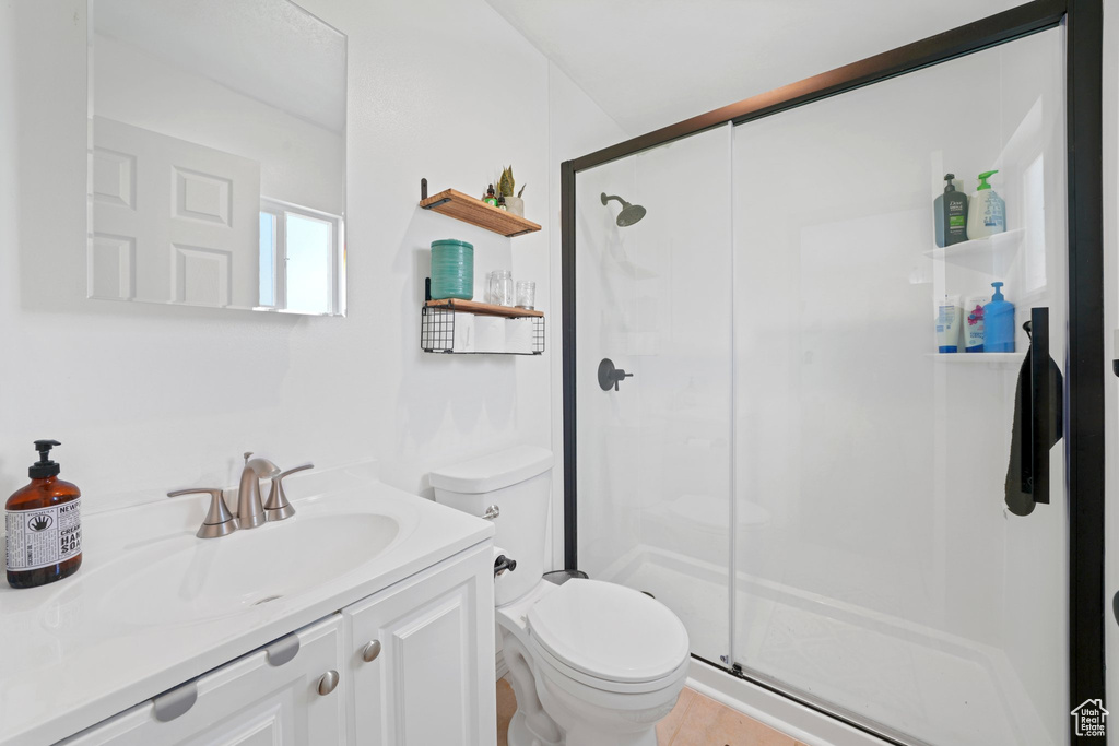 Bathroom featuring vanity with extensive cabinet space, toilet, and walk in shower