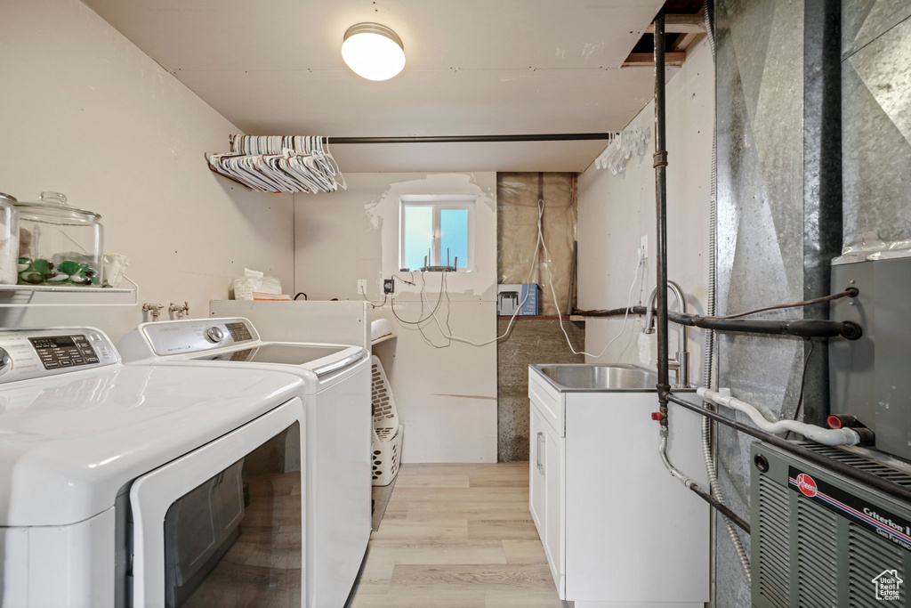 Laundry room with cabinets, independent washer and dryer, light wood-type flooring, and hookup for a washing machine