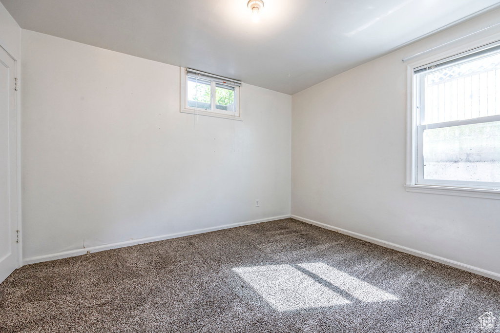 Spare room with a wealth of natural light and carpet flooring