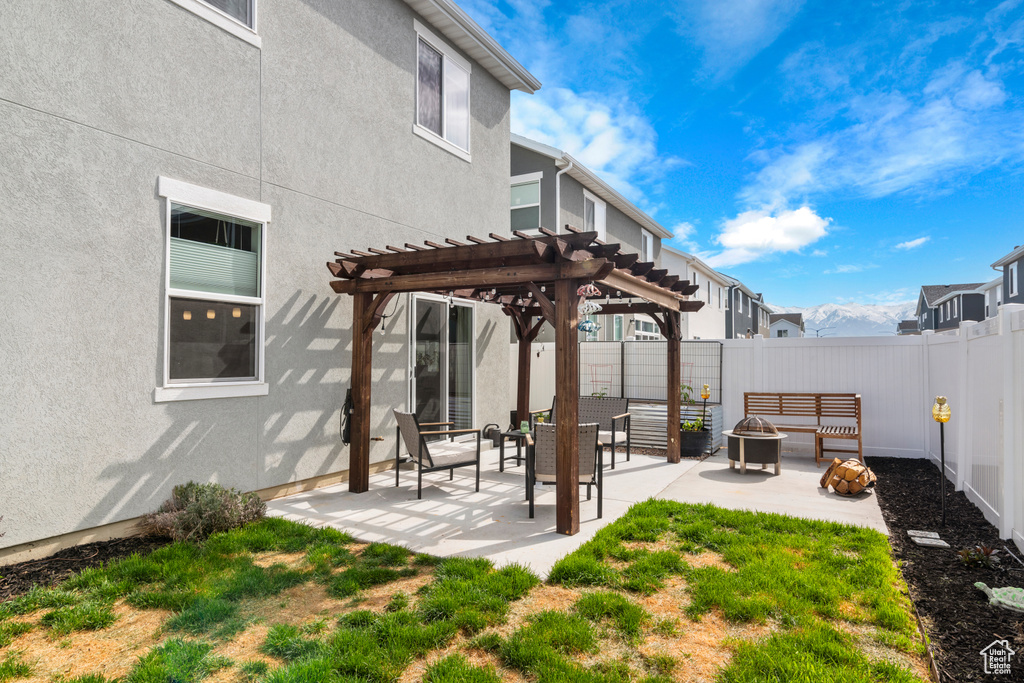 Exterior space featuring an outdoor fire pit, a patio, and a pergola