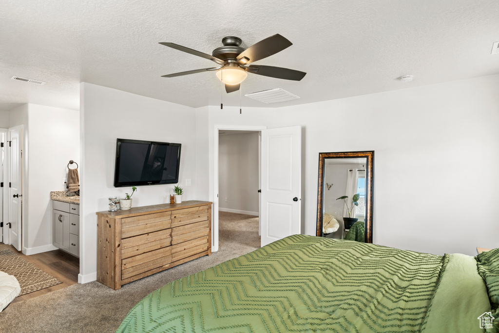Bedroom with carpet flooring, ceiling fan, a textured ceiling, and ensuite bathroom