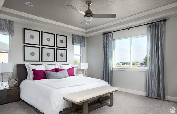 Bedroom featuring light carpet, ceiling fan, ornamental molding, and a tray ceiling