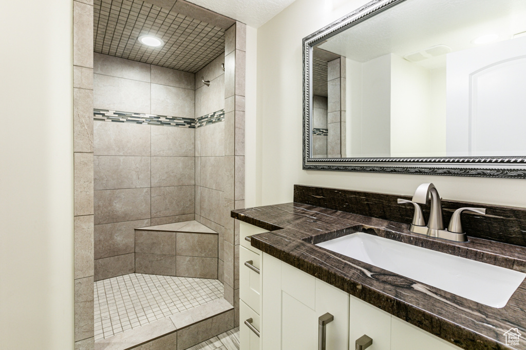 Bathroom featuring vanity and tiled shower