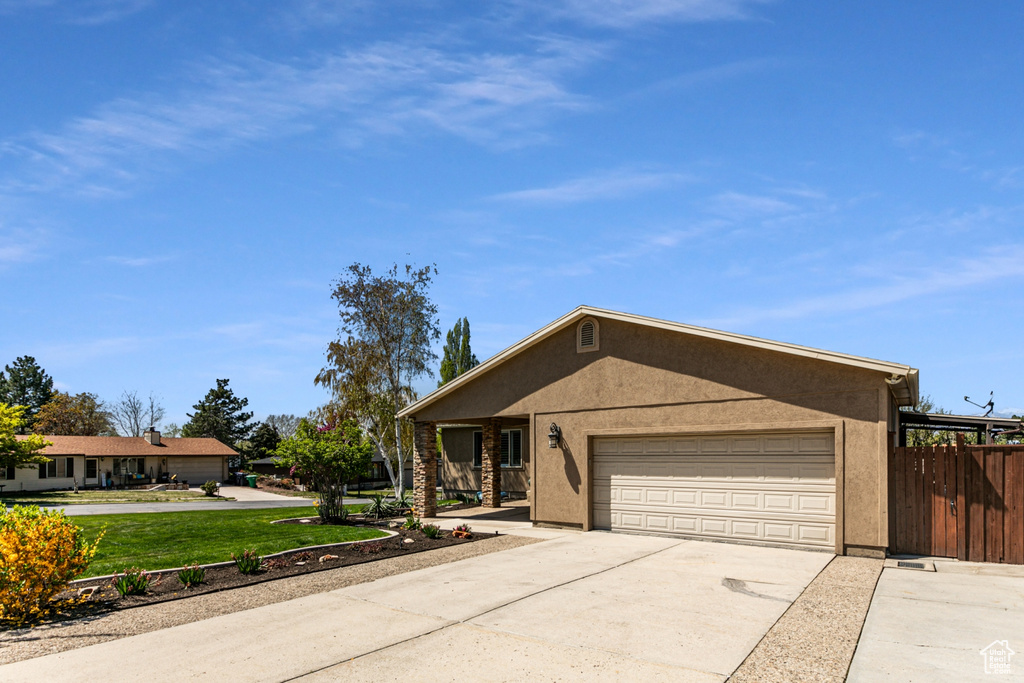 Ranch-style house featuring a garage and a front yard