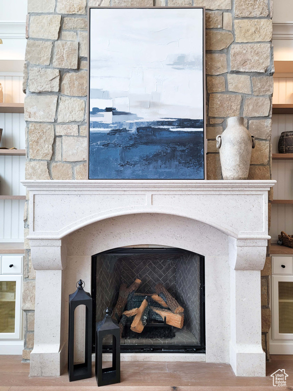 Room details featuring a stone fireplace and hardwood / wood-style flooring