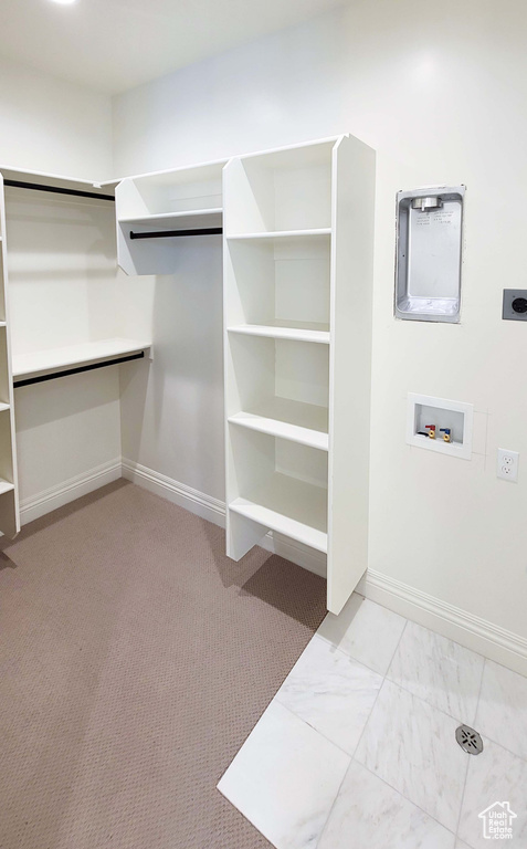 Walk in closet featuring light colored carpet