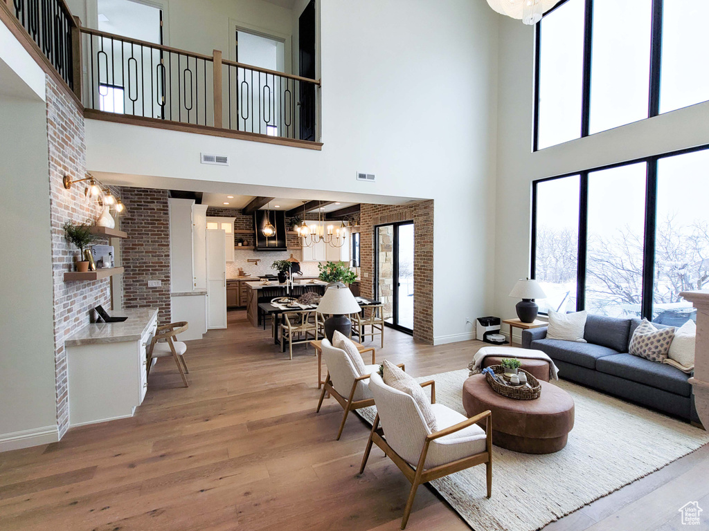 Living room with a high ceiling and light hardwood / wood-style flooring