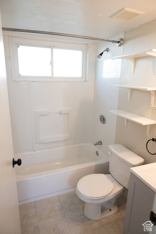 Full bathroom with tile flooring, vanity, toilet, and shower / washtub combination