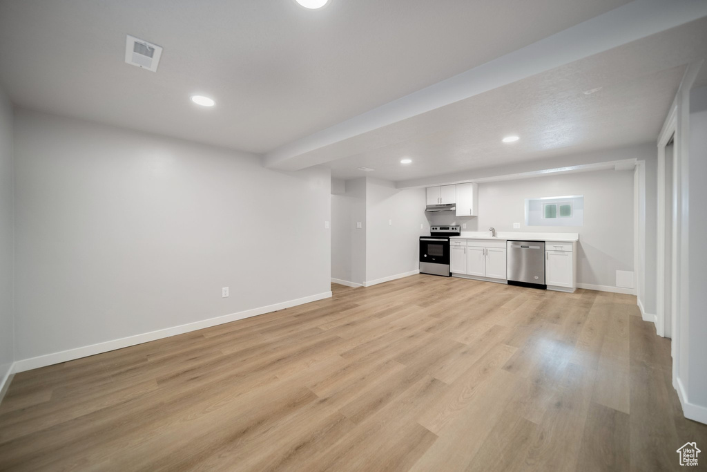 Unfurnished living room with sink and light hardwood / wood-style floors