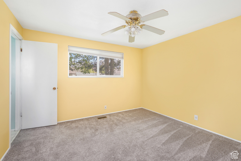 Unfurnished room with ceiling fan and carpet flooring