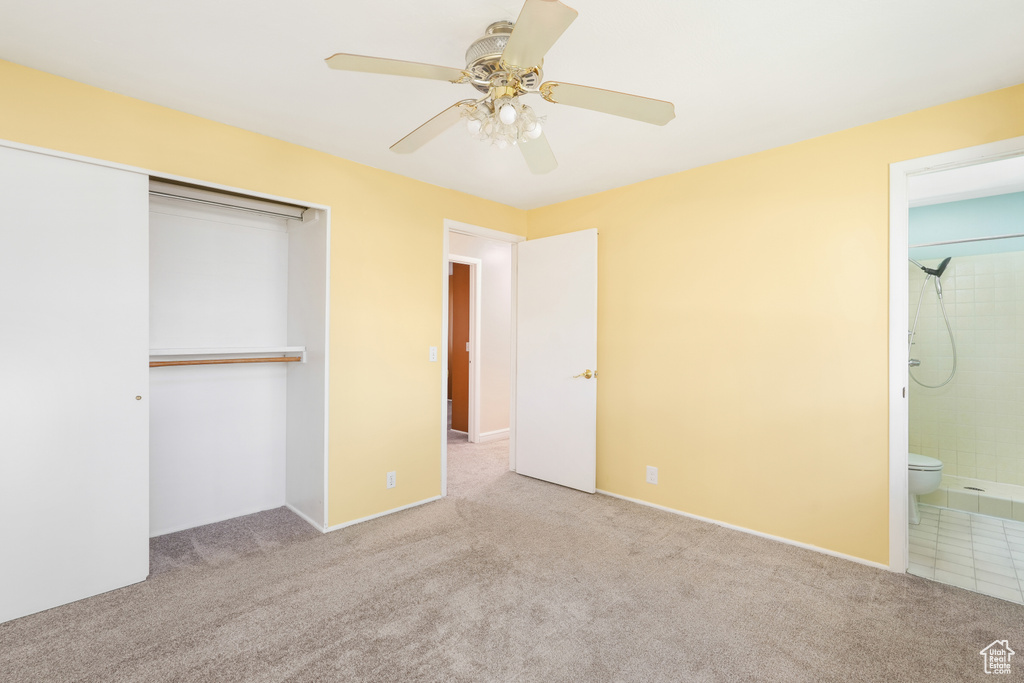 Unfurnished bedroom featuring a closet, ceiling fan, carpet, and ensuite bathroom