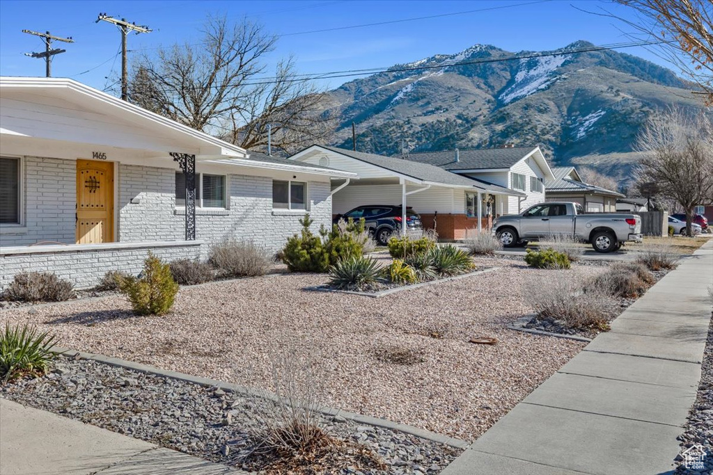 View of front of property with a mountain view and a carport