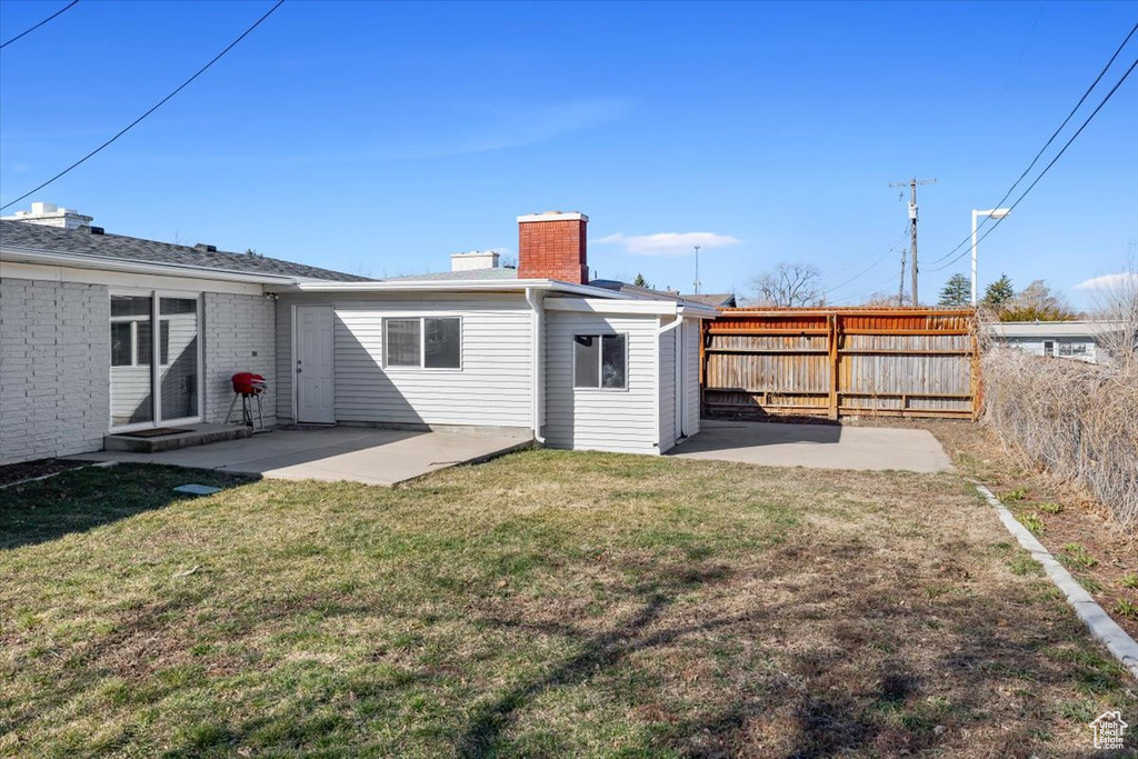 Rear view of property with a patio and a yard