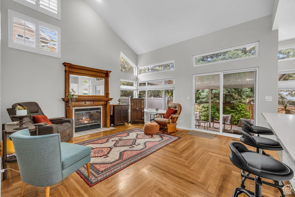 Living room featuring plenty of natural light, high vaulted ceiling, and light parquet flooring