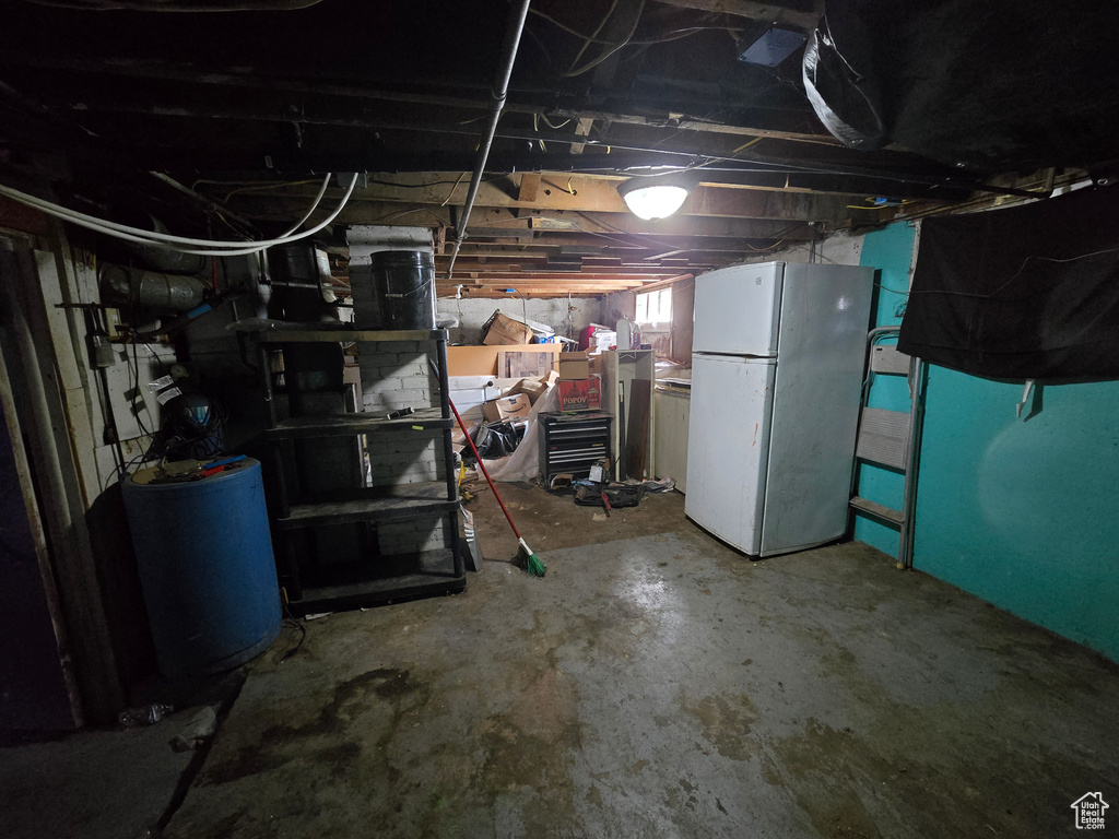 Basement with white refrigerator