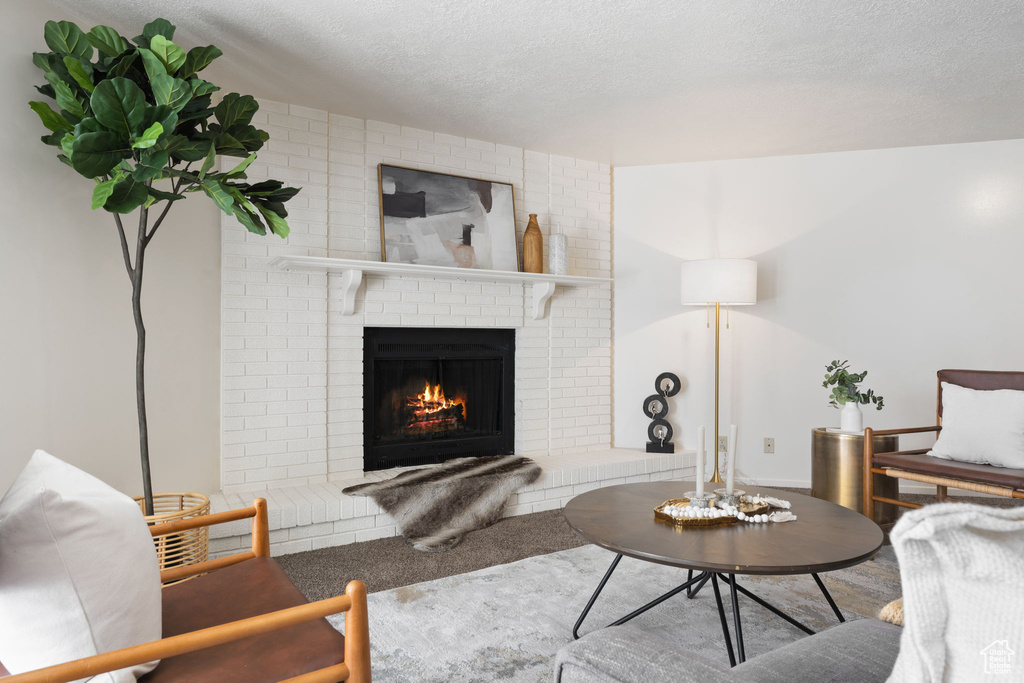 Living room with a fireplace and a textured ceiling