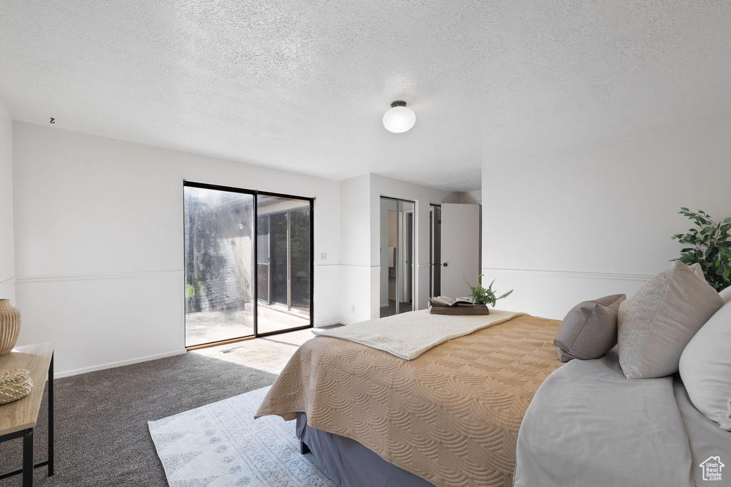 Carpeted bedroom featuring a textured ceiling and access to exterior