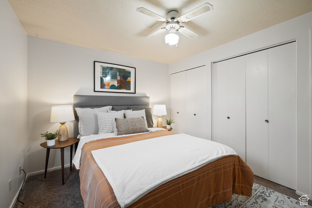 Bedroom featuring ceiling fan, carpet, and multiple closets