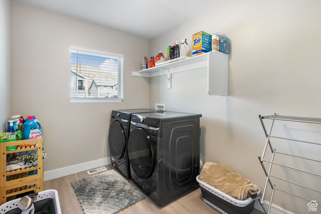Laundry area with washer hookup, light hardwood / wood-style flooring, and separate washer and dryer