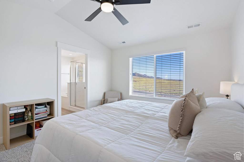 Bedroom with lofted ceiling, ceiling fan, and ensuite bath