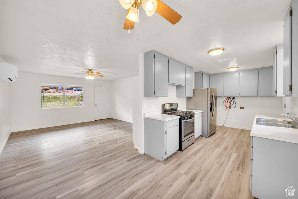 Kitchen featuring ceiling fan, sink, stainless steel appliances, and light hardwood / wood-style floors