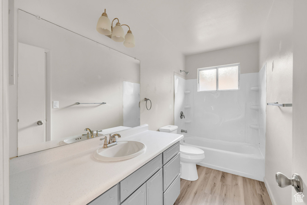 Full bathroom featuring vanity, hardwood / wood-style floors, shower / bathtub combination, and toilet