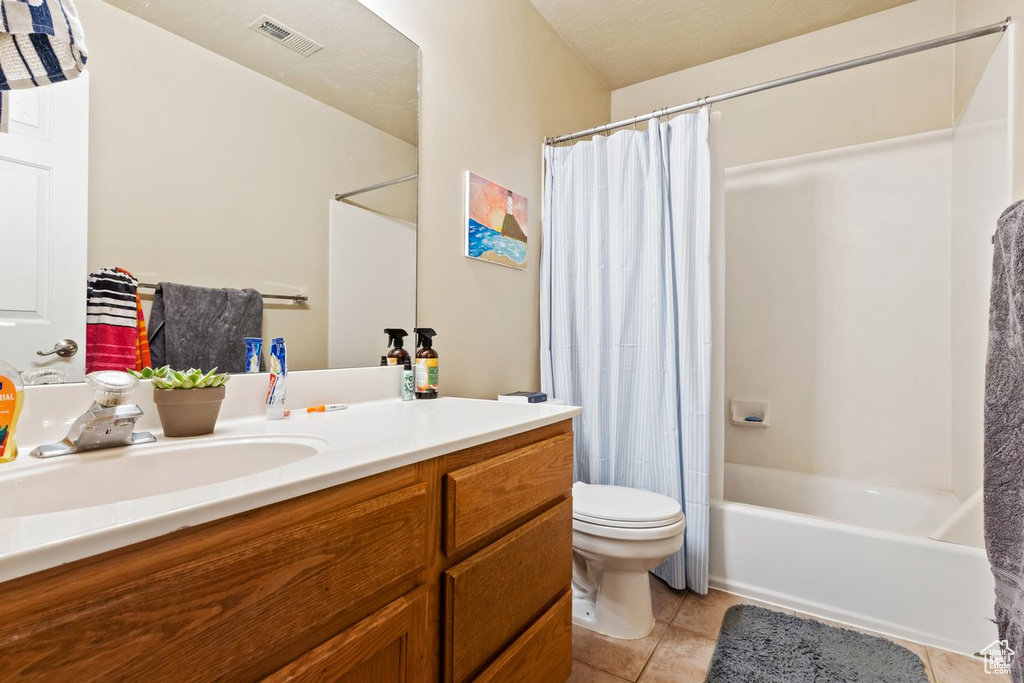 Full bathroom with shower / bath combo, toilet, oversized vanity, and tile flooring