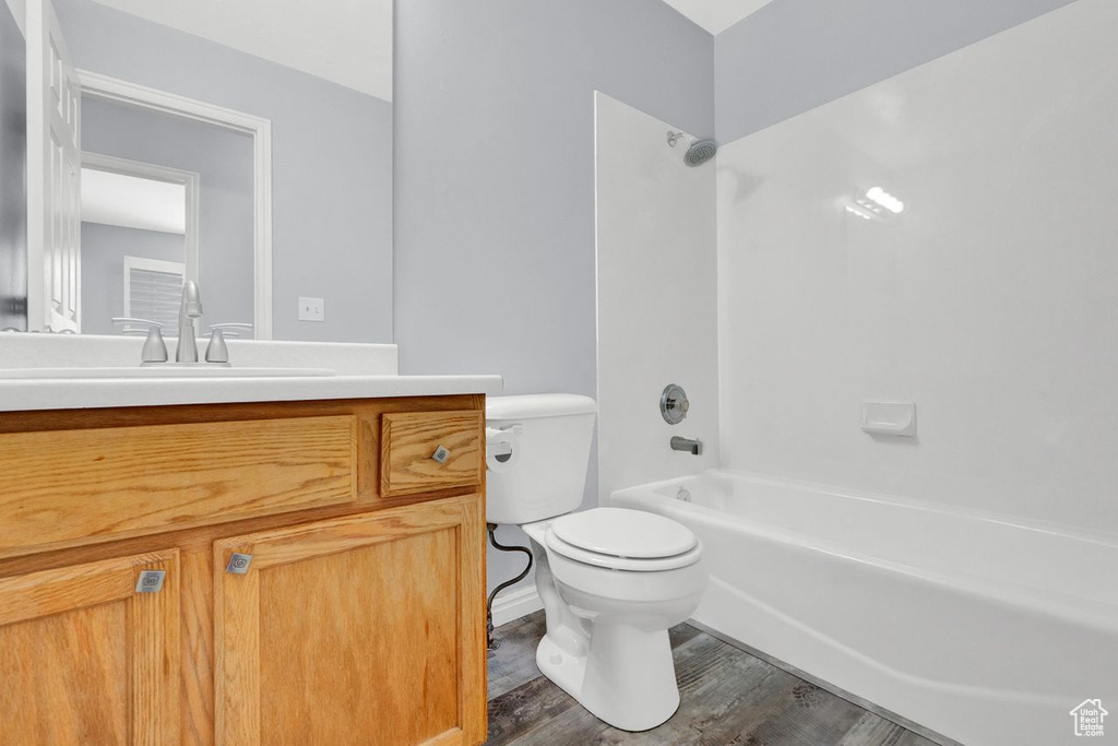 Full bathroom featuring shower / bath combination, hardwood / wood-style floors, vanity, and toilet