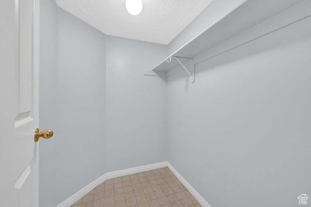 Spacious closet featuring tile flooring