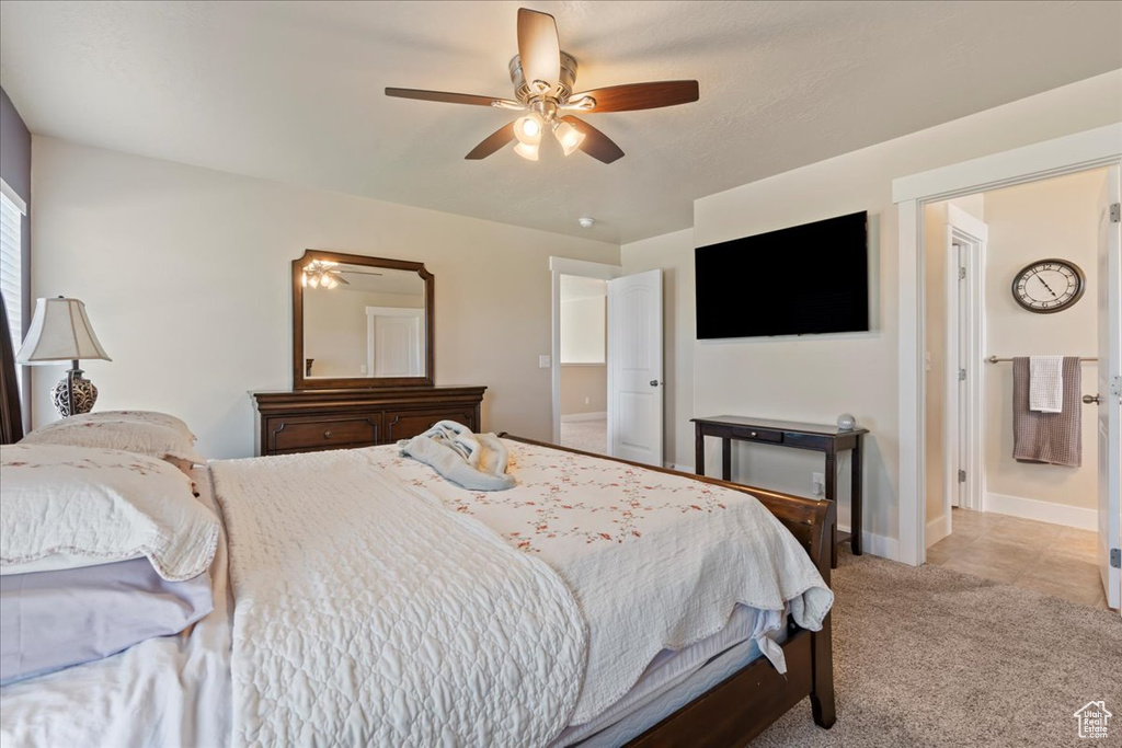 Tiled bedroom with connected bathroom and ceiling fan