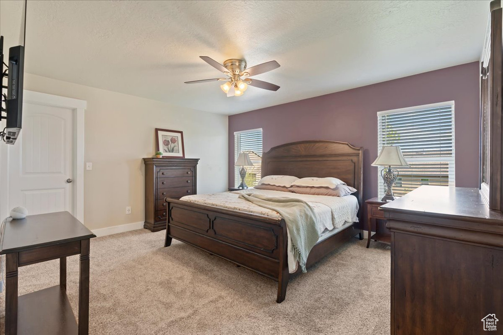 Bedroom with ceiling fan, carpet, and multiple windows