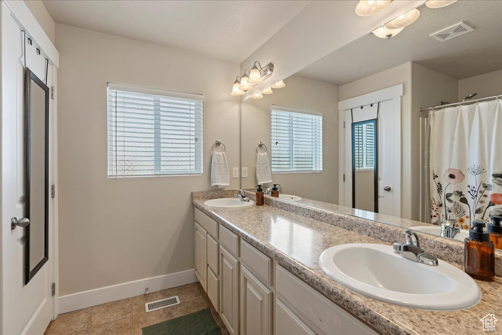 Bathroom with plenty of natural light, tile floors, and double vanity