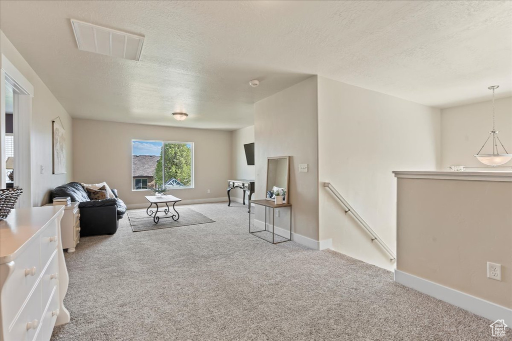 Living room featuring light carpet and a textured ceiling